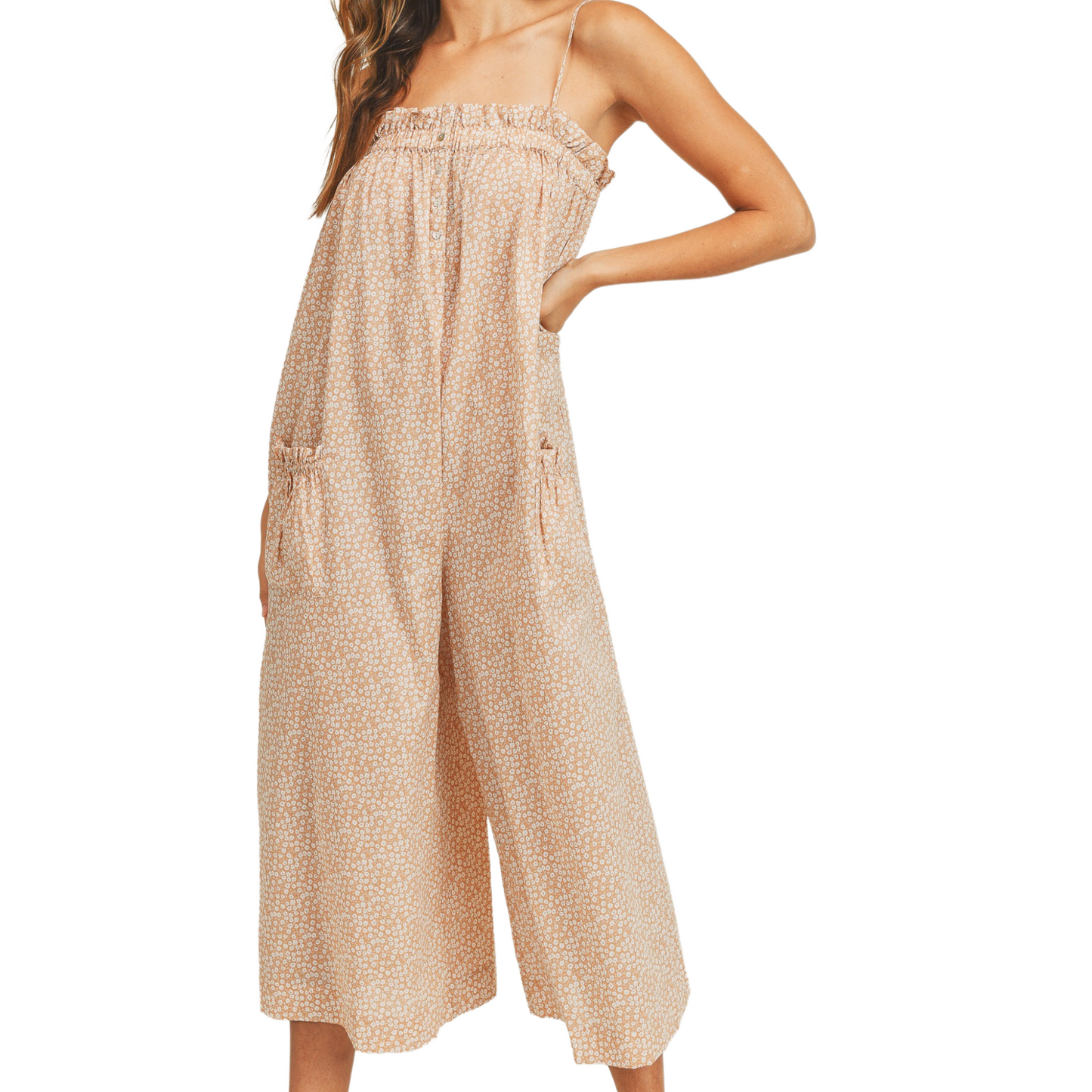 Peach floral jumpsuit with wide leg pants and pockets, worn by a woman from the front.