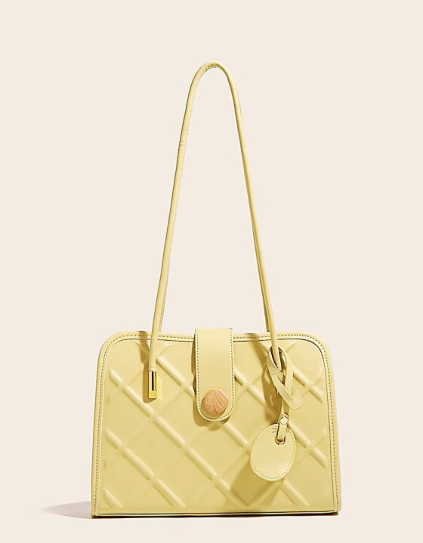 Light green textured bag with long strap and wooden button, shown from the front.