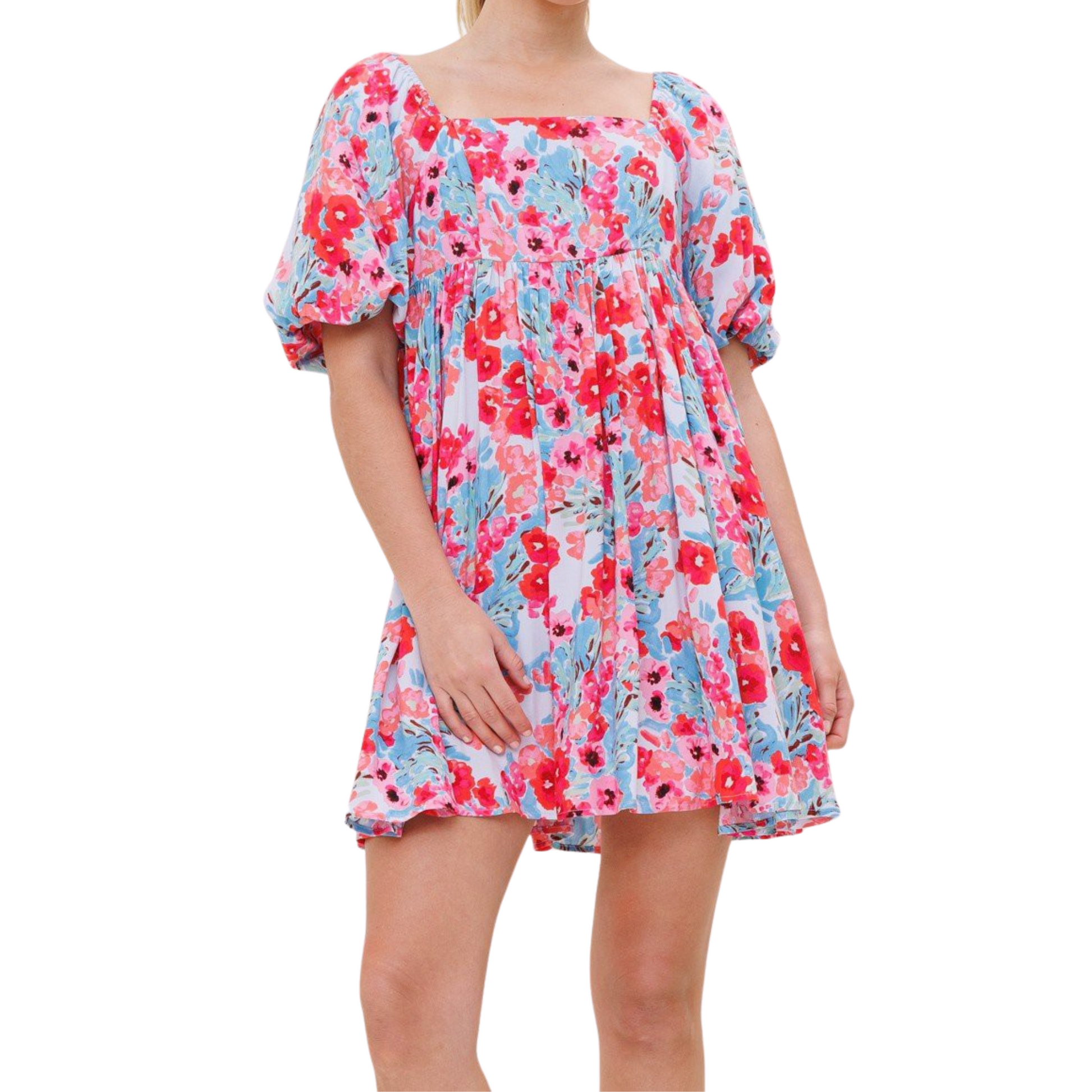 Pink, blue and white floral mini dress with balloon sleeves and square back, worn by a woman from the front.
