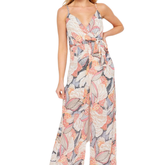 Multicolor jumpsuit with floral pattern and tie, worn by a woman from the front.